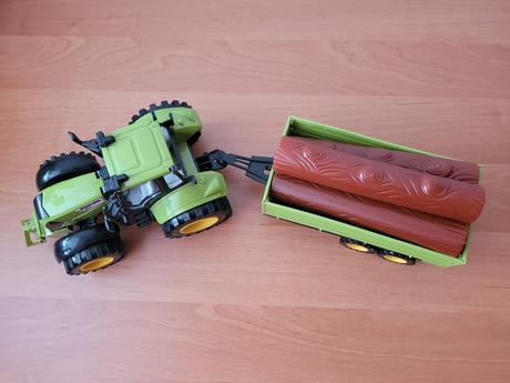 Větší traktor s naloženou vlečkou,