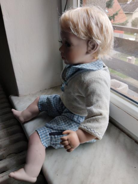 Sedící porcelánový kluk,