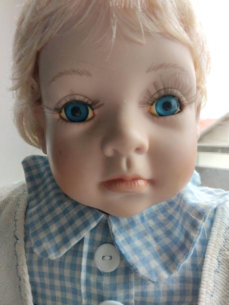 Sedící porcelánový kluk,