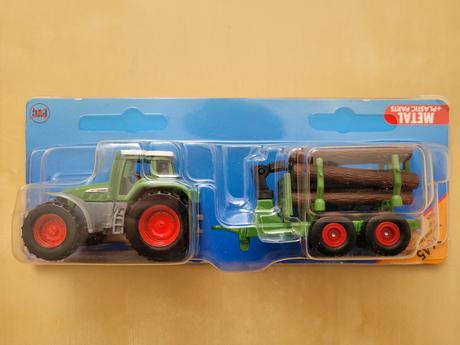 Malý traktor s naloženou vlečkou,