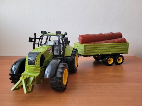 Větší traktor s naloženou vlečkou,