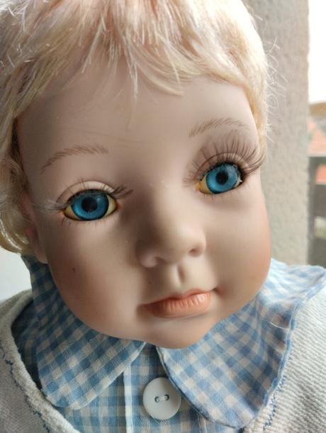 Sedící porcelánový kluk,