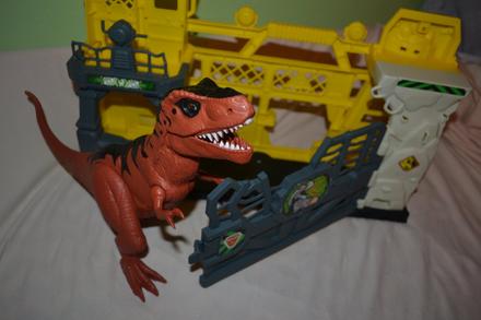 Velký dinosaurus řve a svítí, v ohradě,