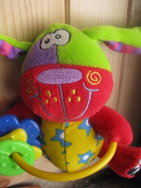 Plyšový pejsek v pestrých barvách,