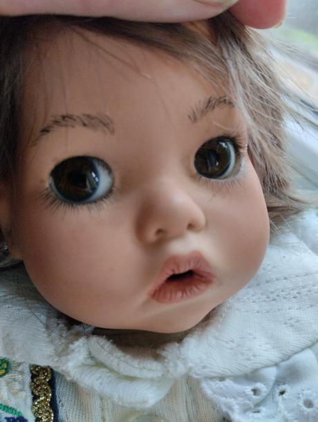 Značená sedící porcelánová panenka,