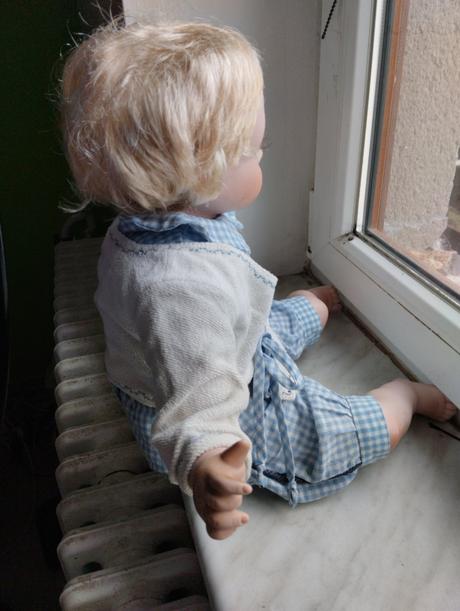 Sedící porcelánový kluk,