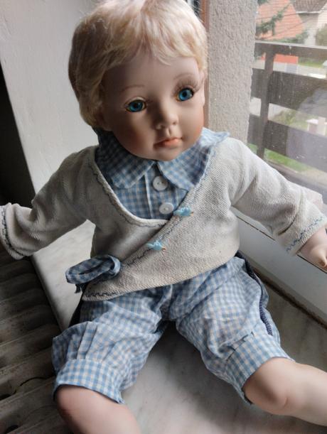 Sedící porcelánový kluk,